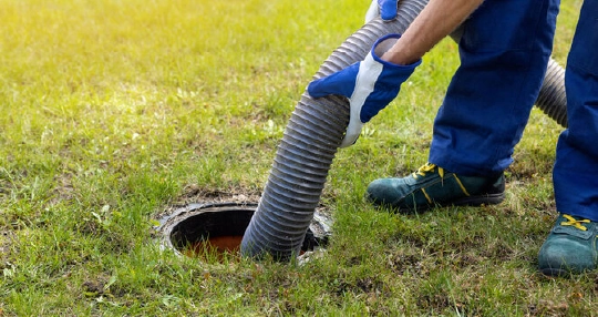 Technician using a service hose to help prevent septic emergencies