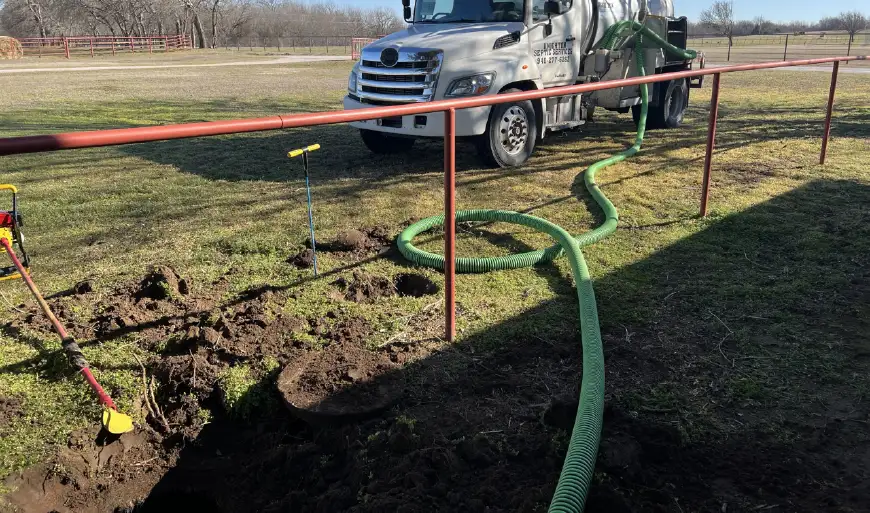 Septic service truck pumping a rural residential system with a hose